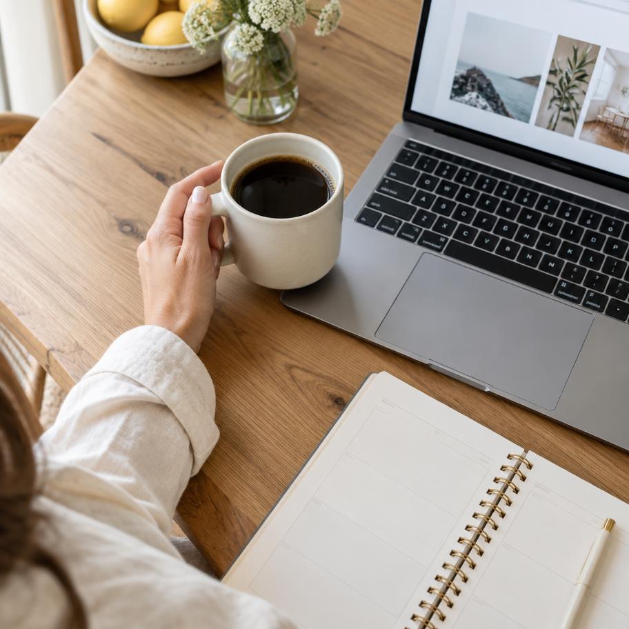 Coffee, a laptop and a planner on a sunlit kitchen table